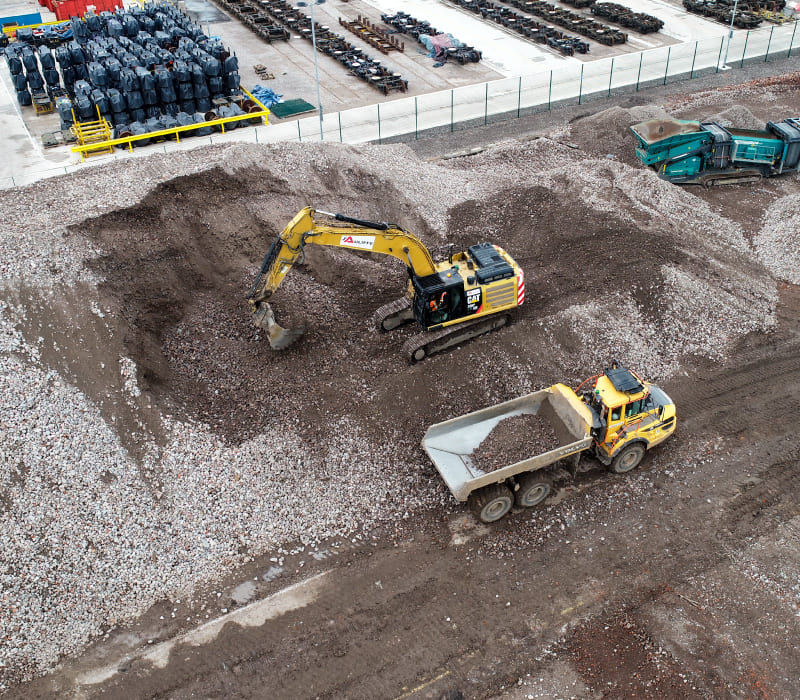 Brownfield remediation and earthworks at this site in Crewe, Cheshire featuring yellow heavy digging machinery and material transportation vehicles.