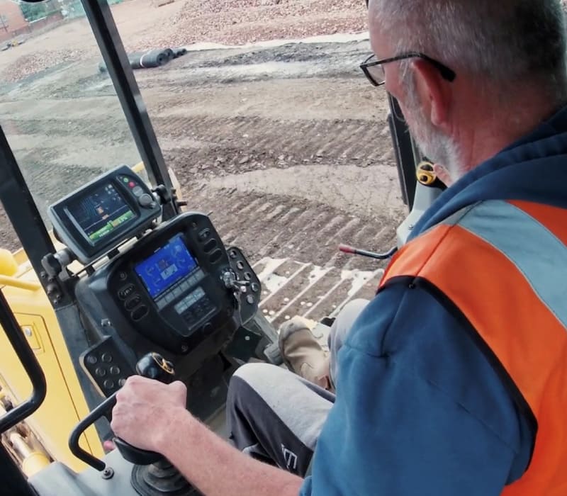 Inside view of McAuliffe team member operating yellow remediation machinery.